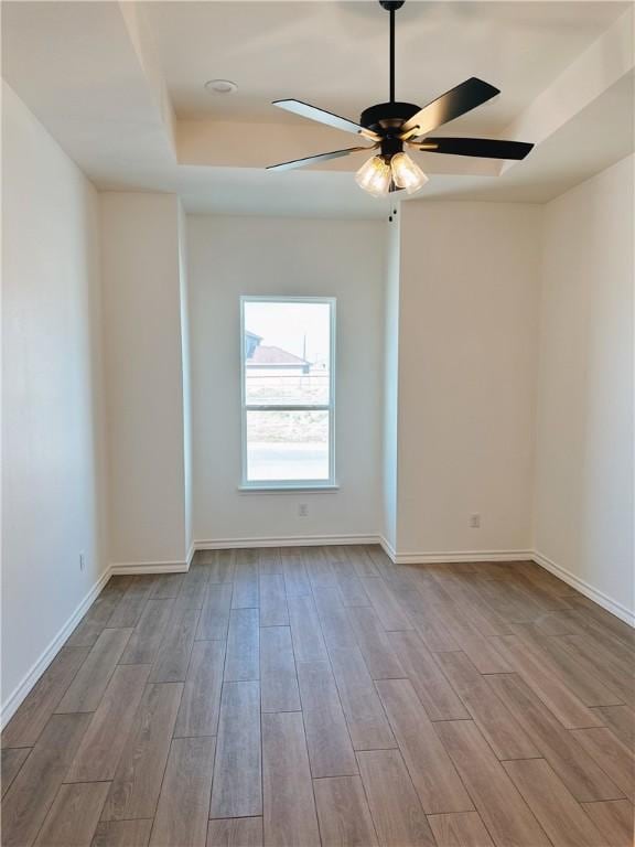 unfurnished room featuring baseboards, a ceiling fan, and wood finished floors