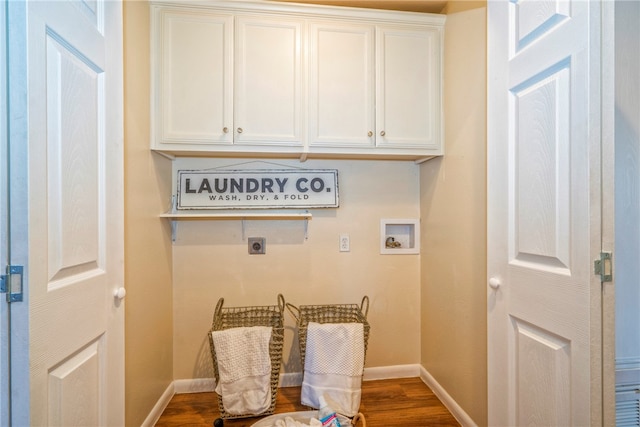 laundry area with hookup for an electric dryer, hookup for a washing machine, dark wood-type flooring, and cabinets