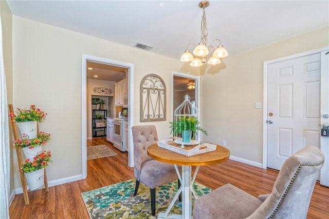 dining room with a chandelier and hardwood / wood-style floors