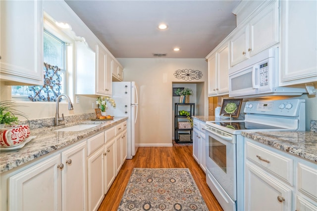 kitchen with white cabinetry, white appliances, and sink