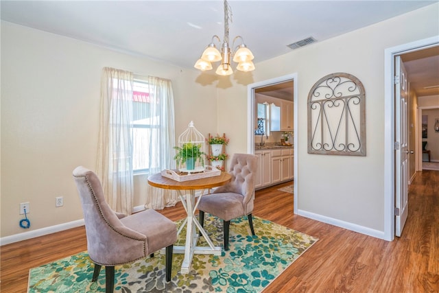 dining area with a notable chandelier and light hardwood / wood-style floors