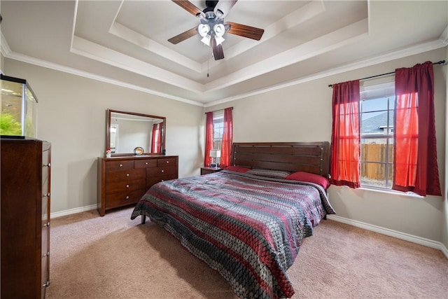 carpeted bedroom with a raised ceiling, ornamental molding, and ceiling fan