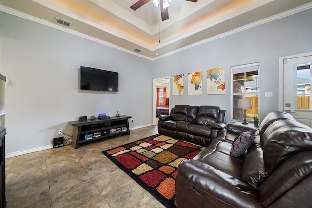 living room featuring ceiling fan, ornamental molding, a tray ceiling, and tile patterned floors