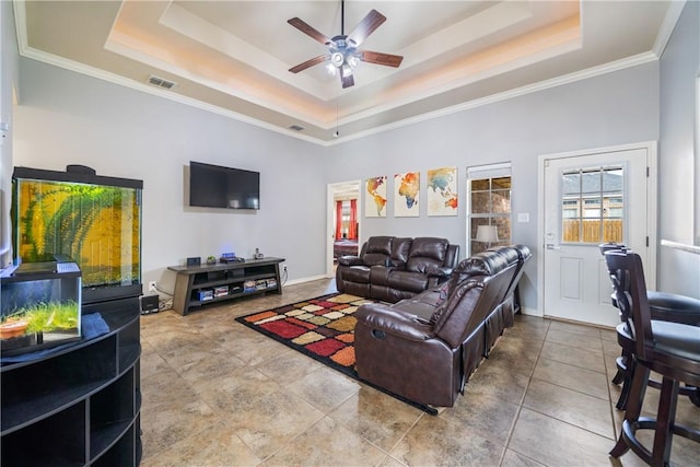 living room with a raised ceiling, a towering ceiling, tile patterned floors, and ceiling fan