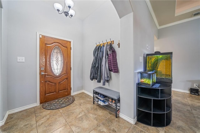 foyer entrance featuring tile patterned flooring, crown molding, and a chandelier