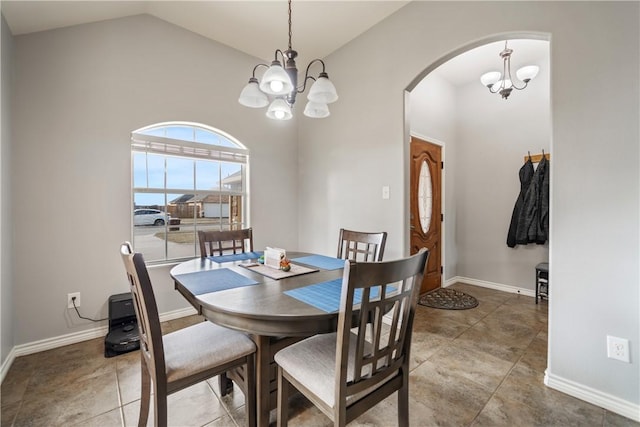 tiled dining room with high vaulted ceiling and a chandelier