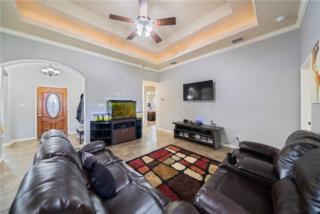 living room featuring a raised ceiling, ceiling fan with notable chandelier, and light tile patterned floors