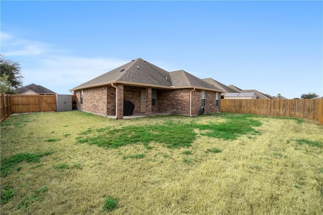 rear view of property with a yard and a patio area