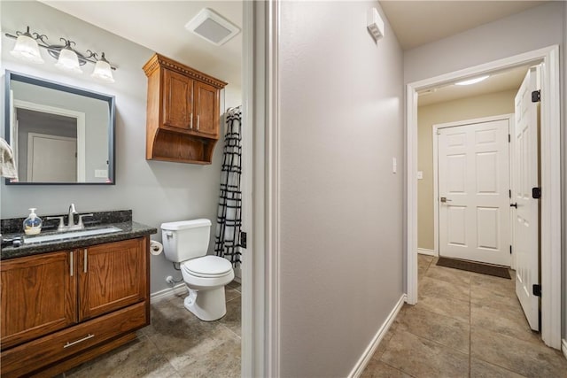 bathroom featuring vanity, tile patterned flooring, and toilet