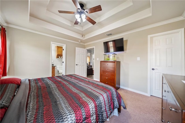 carpeted bedroom with ensuite bathroom, ceiling fan, ornamental molding, and a raised ceiling