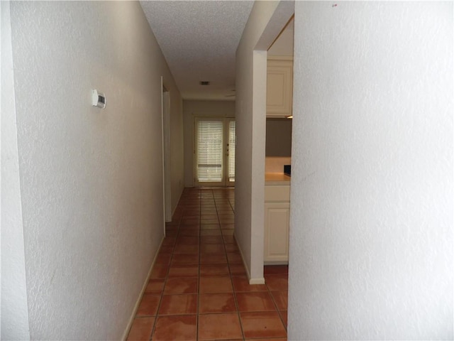 13656 Teague Ln Unit 33, Corpus Christi, TX 78410 - hall with light tile patterned flooring, a textured wall, and a textured ceiling