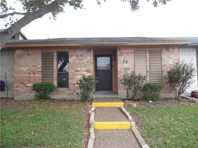 13656 Teague Ln Unit 33, Corpus Christi, TX 78410 - view of front of house with brick siding, a front lawn, and uncovered parking