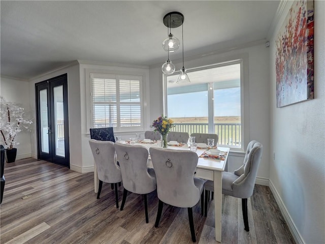 dining area featuring french doors, wood-type flooring, and crown molding