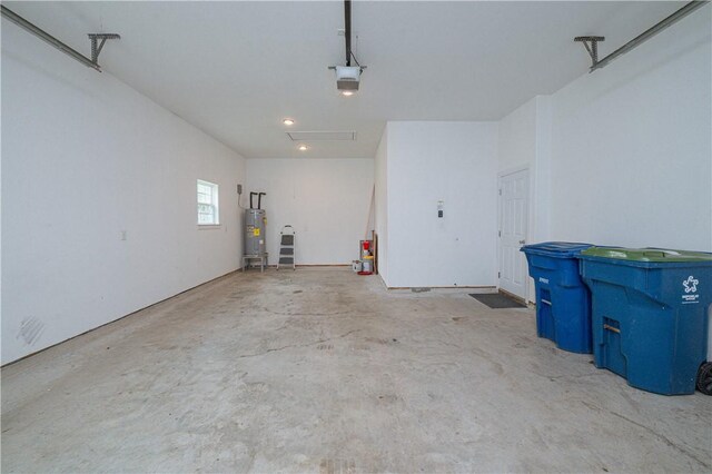 garage with a garage door opener and electric water heater