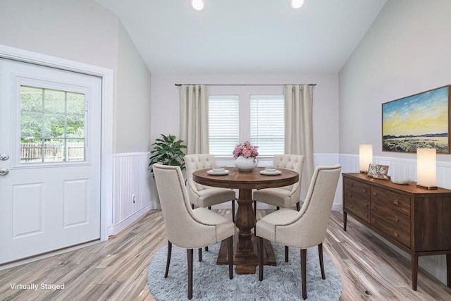 dining room featuring vaulted ceiling and light hardwood / wood-style floors
