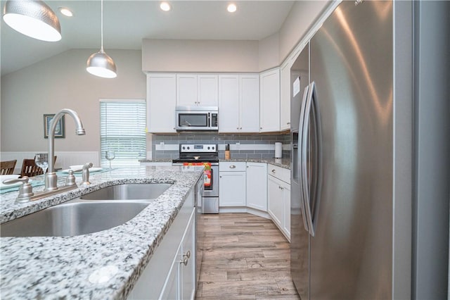 kitchen featuring sink, light hardwood / wood-style flooring, stainless steel appliances, light stone countertops, and white cabinets