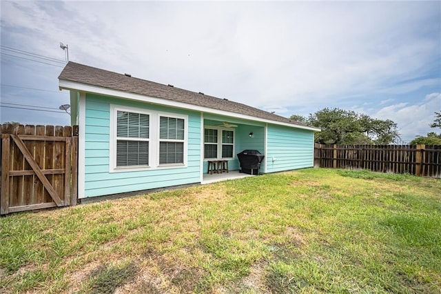 rear view of house featuring a yard, a patio, and ceiling fan