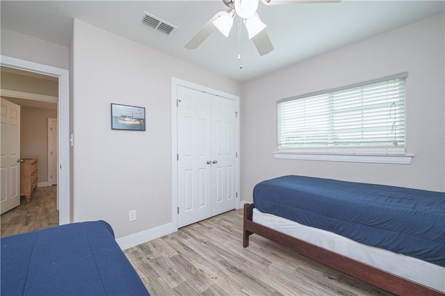 bedroom featuring ceiling fan, light hardwood / wood-style floors, and a closet
