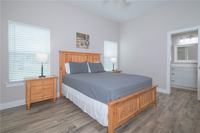 bedroom featuring connected bathroom and dark wood-type flooring