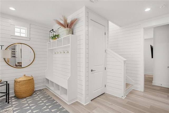 mudroom with baseboards, light wood finished floors, recessed lighting, and wooden walls