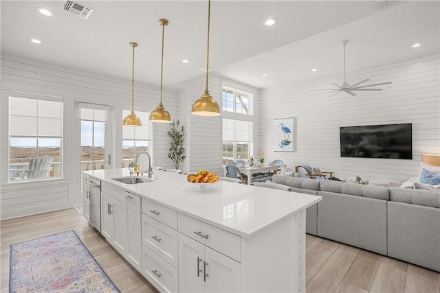 kitchen featuring light wood-style floors, visible vents, a sink, and stainless steel dishwasher