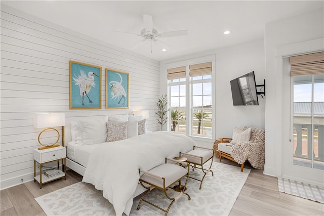 bedroom featuring baseboards, recessed lighting, light wood-style flooring, and access to exterior