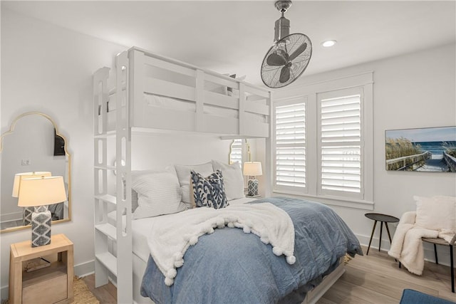 bedroom featuring baseboards, wood finished floors, and recessed lighting