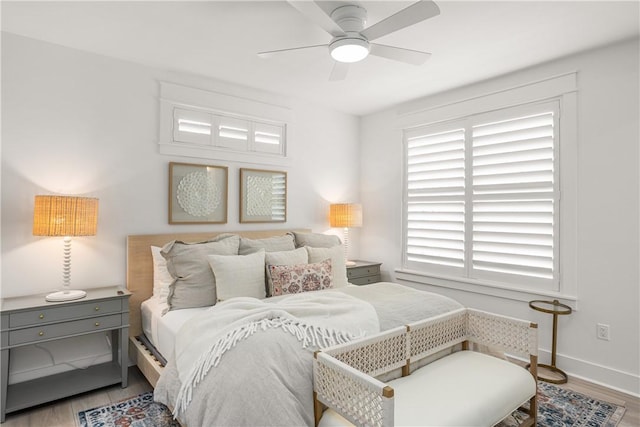 bedroom with wood finished floors, a ceiling fan, and baseboards