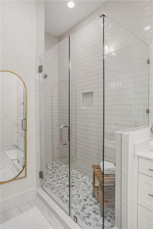 full bathroom with a stall shower, vanity, and tile patterned floors