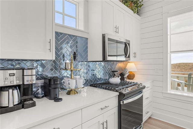 kitchen featuring a healthy amount of sunlight, backsplash, stainless steel appliances, and light countertops