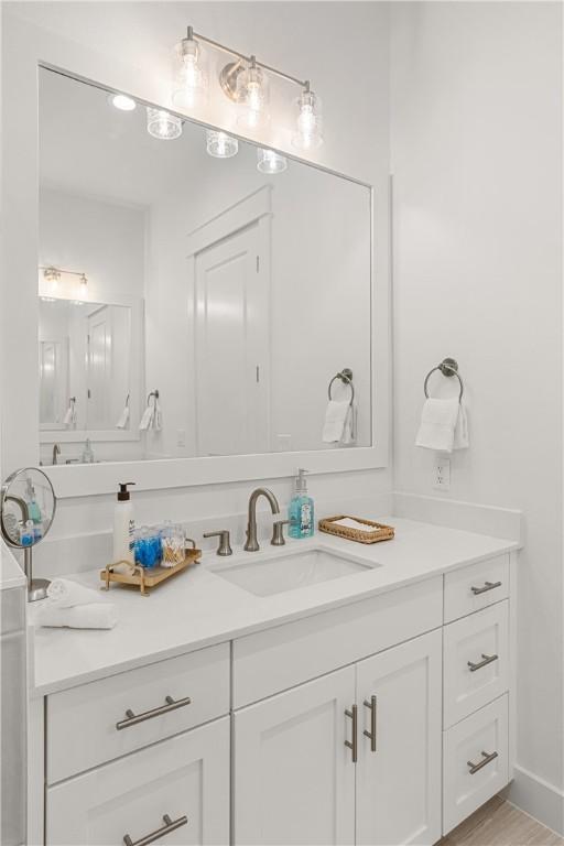 bathroom with wood finished floors and vanity