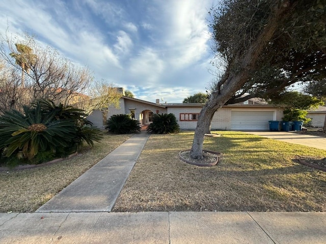 ranch-style home featuring a garage and a front lawn