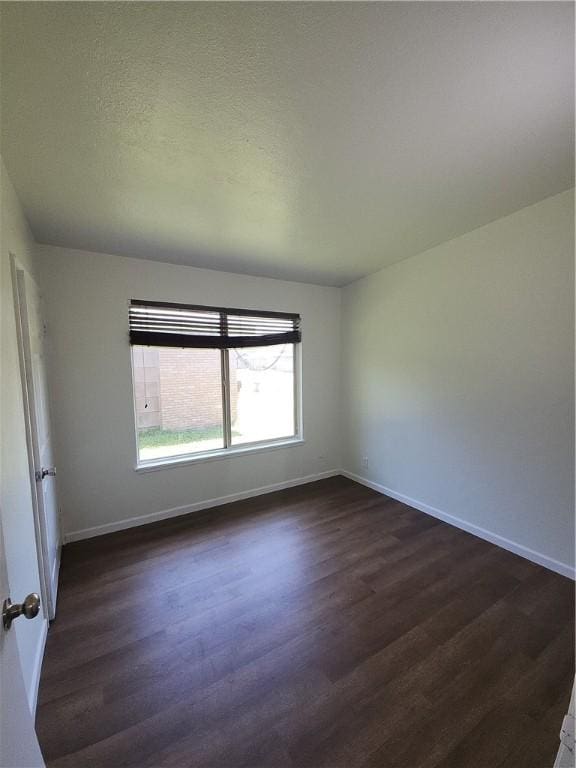 1514 E Johnston Ave, Kingsville, TX 78363 - unfurnished room with baseboards and dark wood-type flooring