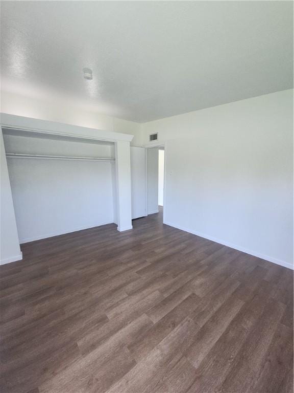 1514 E Johnston Ave, Kingsville, TX 78363 - unfurnished bedroom with baseboards, a closet, visible vents, and dark wood-type flooring