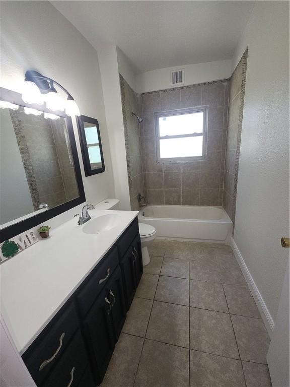 1514 E Johnston Ave, Kingsville, TX 78363 - bathroom featuring toilet,  shower combination, visible vents, tile patterned flooring, and vanity