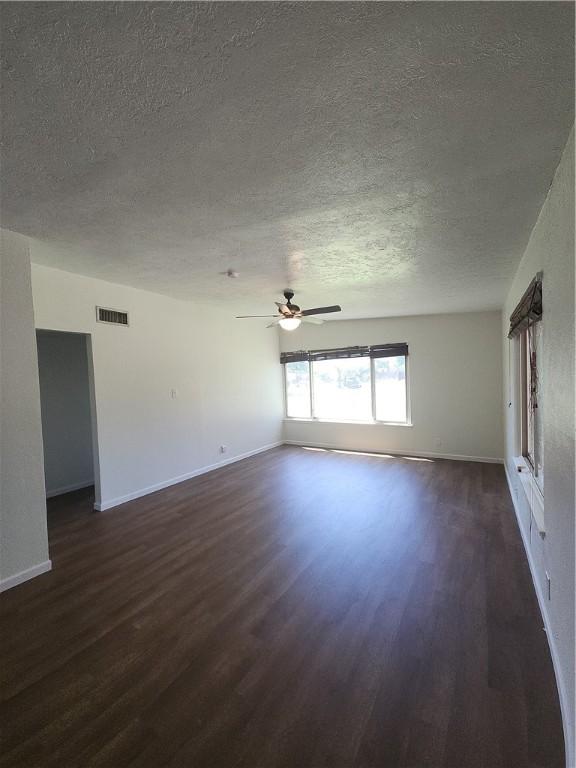 1514 E Johnston Ave, Kingsville, TX 78363 - spare room with ceiling fan, a textured ceiling, dark wood-style floors, and visible vents