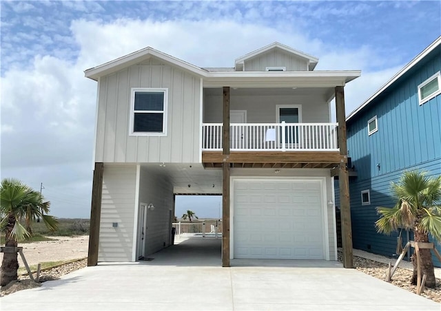  - coastal inspired home with concrete driveway, a carport, an attached garage, and board and batten siding