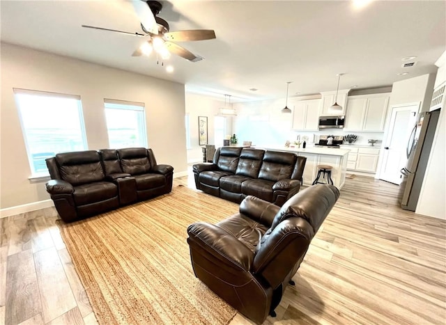 - living room featuring a ceiling fan, light wood finished floors, baseboards, and recessed lighting