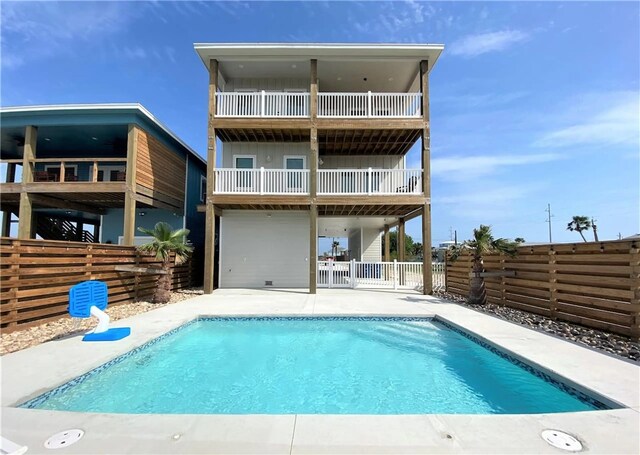 - back of house with a balcony, a fenced backyard, and a patio area