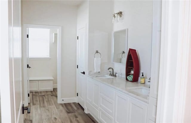  - bathroom with wood finished floors, double vanity, and baseboards