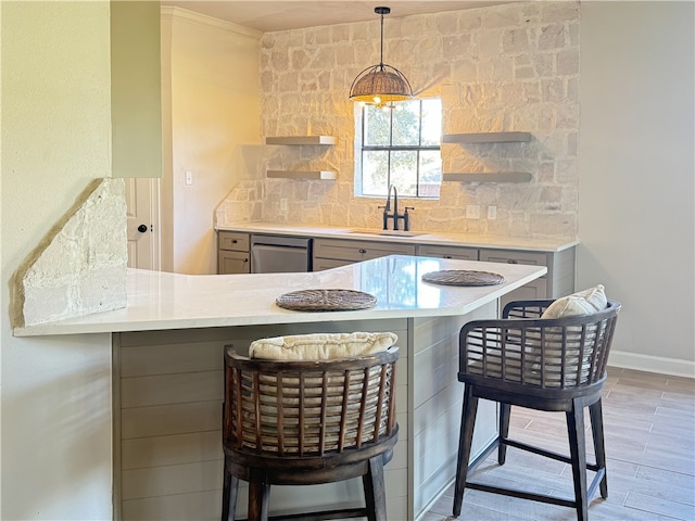 kitchen with dishwasher, a kitchen breakfast bar, sink, light hardwood / wood-style flooring, and kitchen peninsula