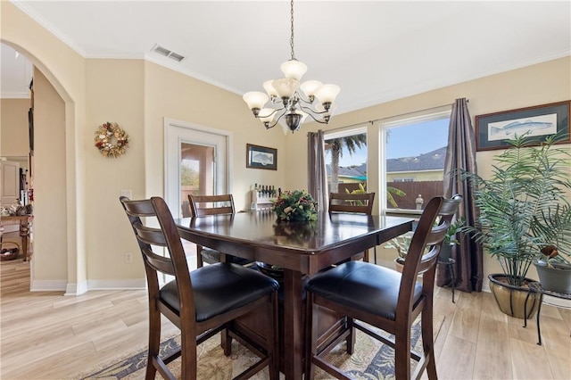 13805 Hawksnest Bay Dr, Corpus Christi, TX 78418 - dining room with a chandelier, arched walkways, light wood-style floors, and ornamental molding