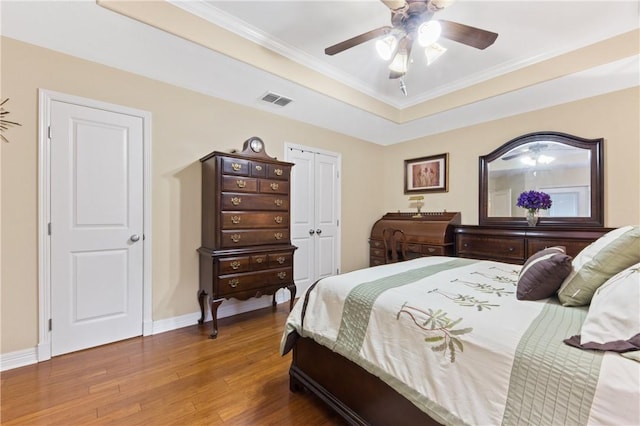 13805 Hawksnest Bay Dr, Corpus Christi, TX 78418 - bedroom featuring wood finished floors, crown molding, a raised ceiling, ceiling fan, and a closet