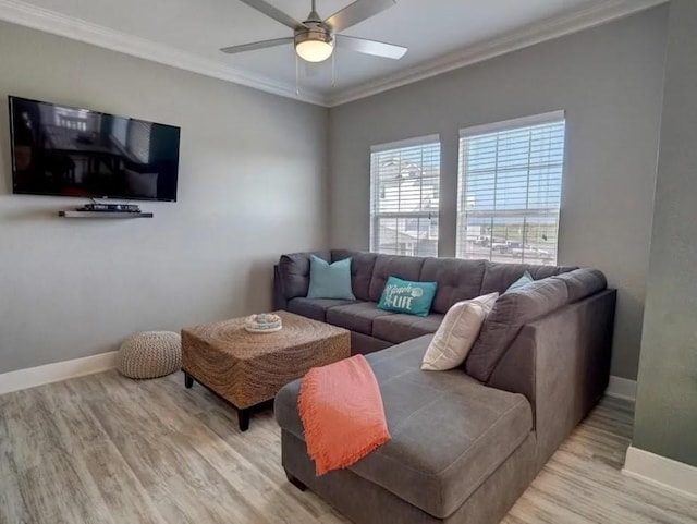 living area with baseboards, a ceiling fan, light wood-style flooring, and ornamental molding