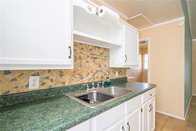 kitchen with white cabinetry, sink, light tile patterned floors, and decorative backsplash