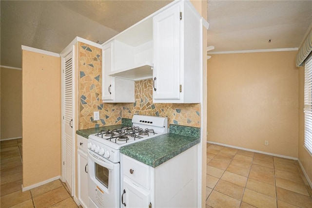 kitchen with light tile patterned flooring, white cabinetry, backsplash, ornamental molding, and white gas range oven