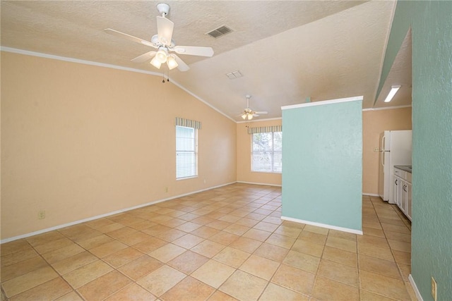 tiled empty room featuring ornamental molding, vaulted ceiling, a textured ceiling, and ceiling fan