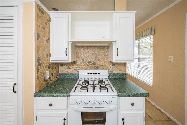 kitchen with backsplash, crown molding, white cabinets, and white gas stove