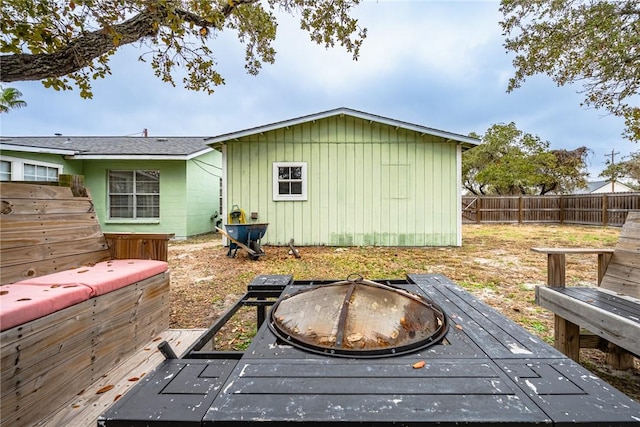 rear view of house with a wooden deck and a fire pit