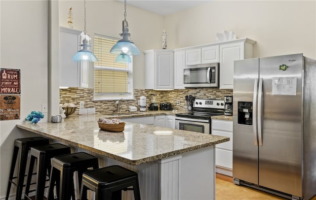 2212 State Highway 361, Port Aransas, TX 78373 - kitchen with stainless steel appliances, a peninsula, white cabinets, and tasteful backsplash